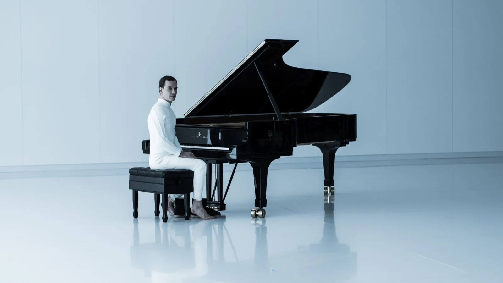 Michael Fassbender dans le rôle de l'androïde David, assis au piano, dans Alien: Covenant