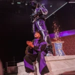 Inoxtag sur scène devant la statue de son skin Fortnite