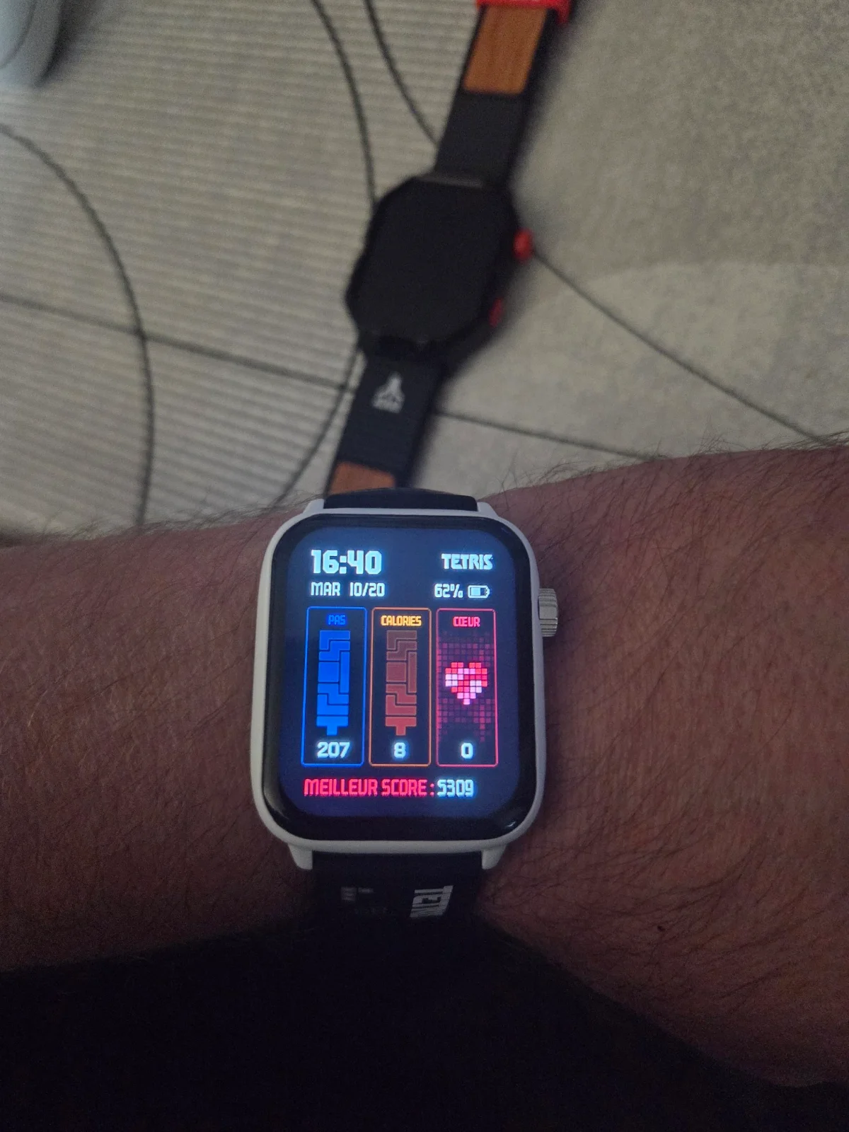 La montre My Play Watch Tetris au poignet, cadran avec pas, calories, fréquence cardiaque et meilleur score