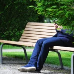 Un joueur de Pokémon GO allongé sur un banc