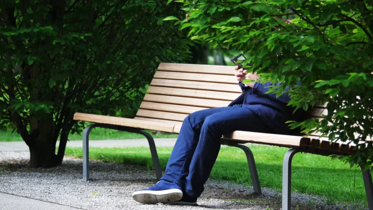 Un joueur de Pokémon GO allongé sur un banc